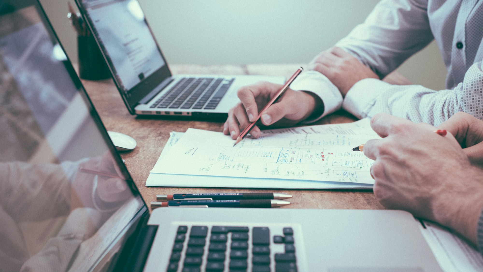 Business owner reviewing website wireframes and timeline documents with a web development team